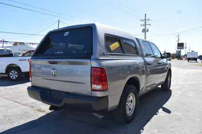 Silver pickup truck with a canopy on a street