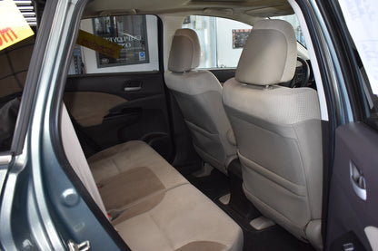 Car interior with beige seats and open door showing a dealership background
