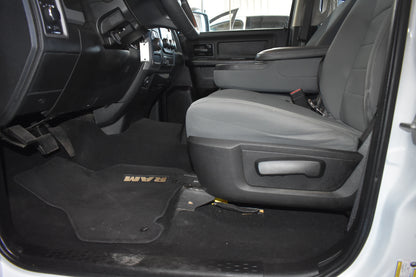 Interior of a vehicle with gray seats and a black floor mat featuring 'FORD' branding.
