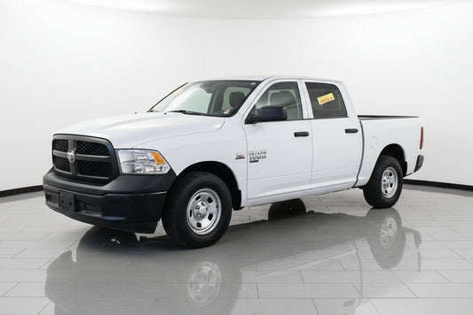 White pickup truck parked in front of a building with a wreath on the door.