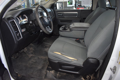 Car interior with gray seats and dashboard, showing the steering wheel and door panel.