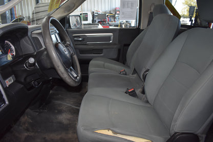 Gray interior of a vehicle with steering wheel and seats.
