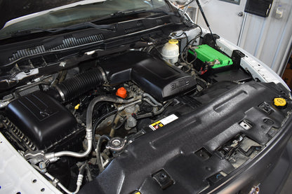 Open car hood revealing the engine compartment with various components.