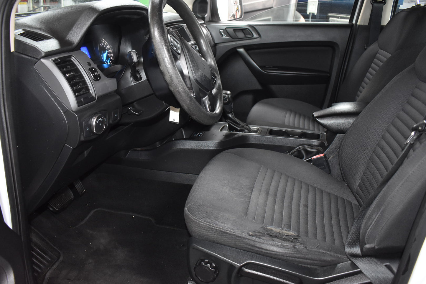 Interior of a vehicle with black leather seats and dashboard.