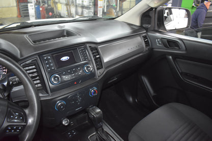 Car interior with dashboard and steering wheel in a workshop setting
