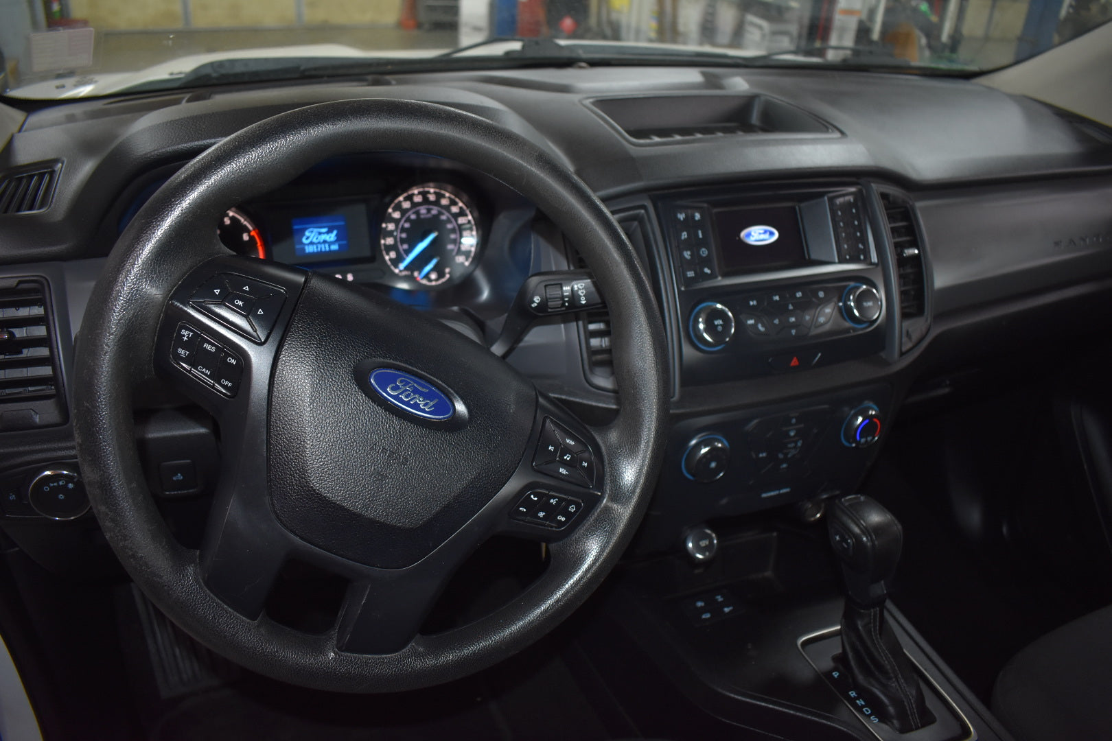 Car interior with steering wheel and dashboard featuring Ford logo