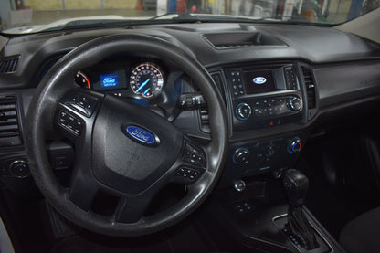 Car interior with steering wheel and dashboard featuring Ford logo