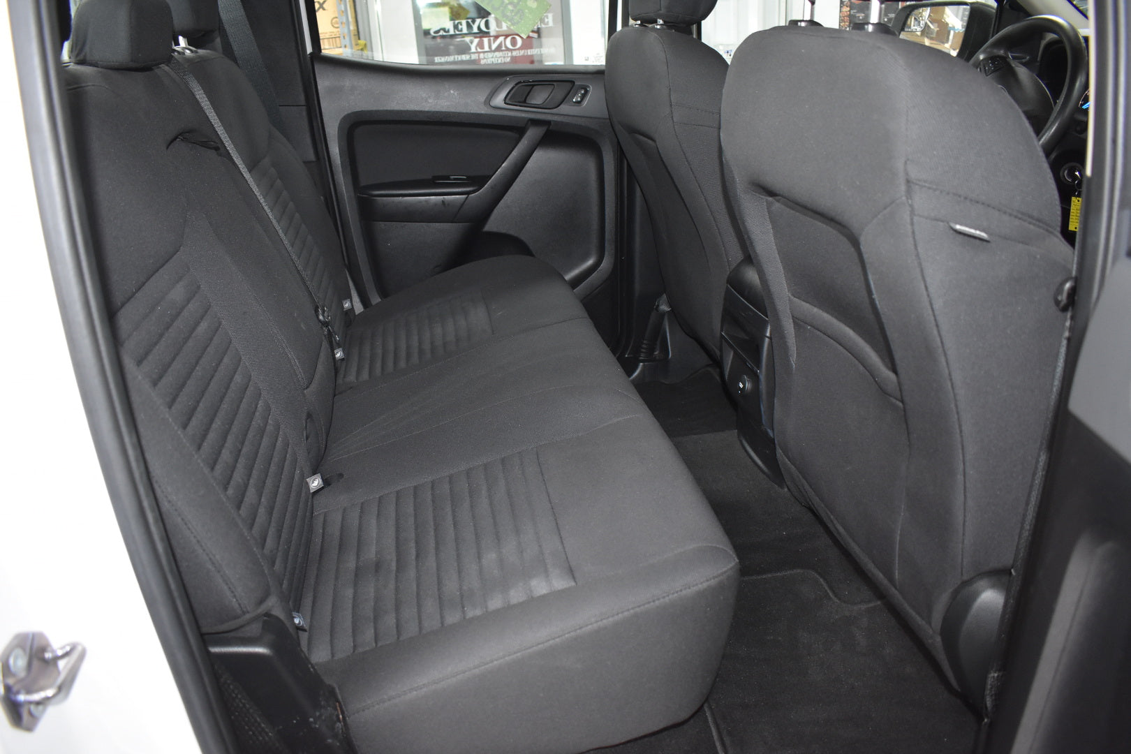 Gray car interior with visible seat belts and door panels.