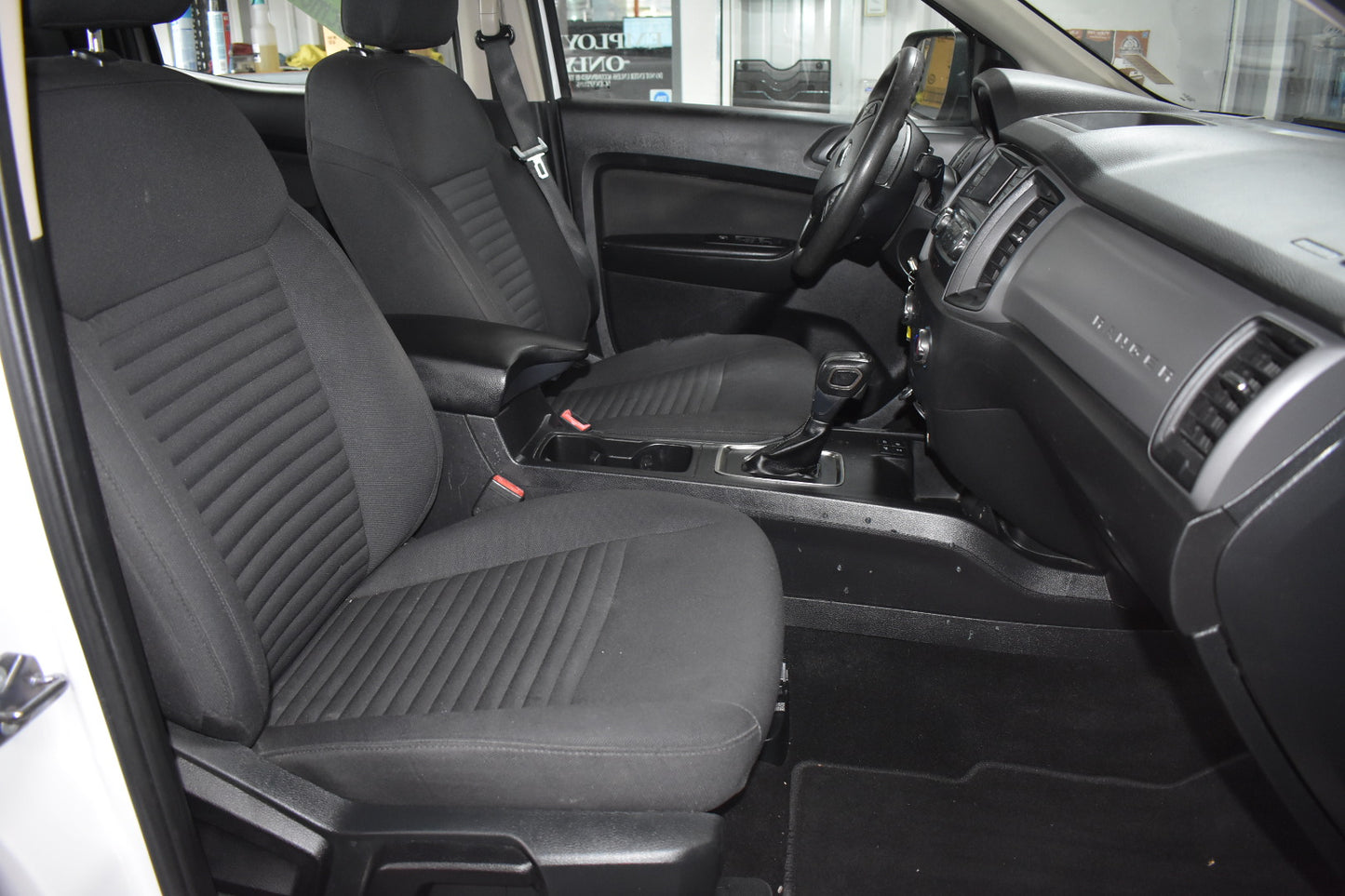 Car interior with black seat covers and visible dashboard.