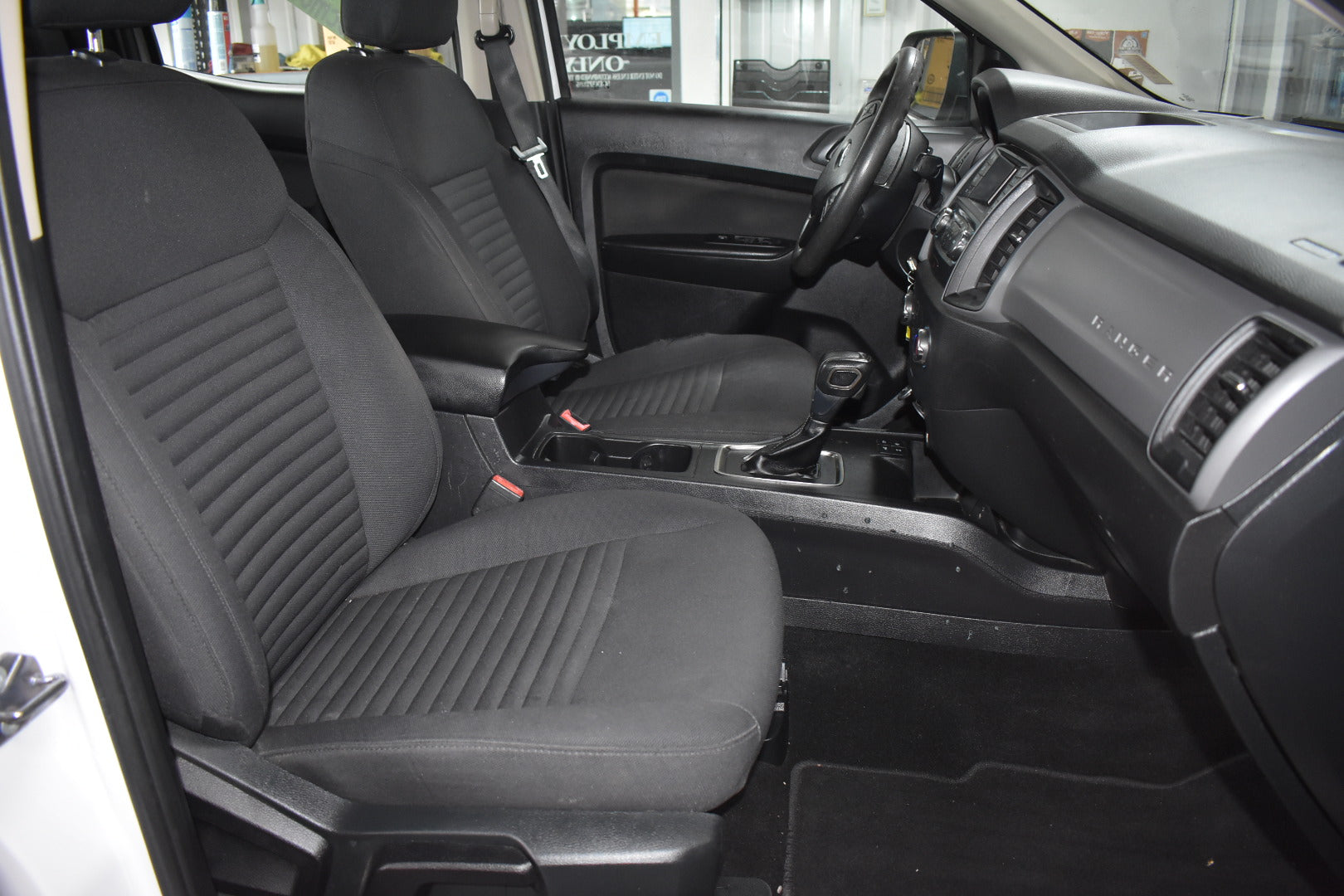 Car interior with black seat covers and visible dashboard.