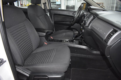 Car interior with black seat covers and visible dashboard.