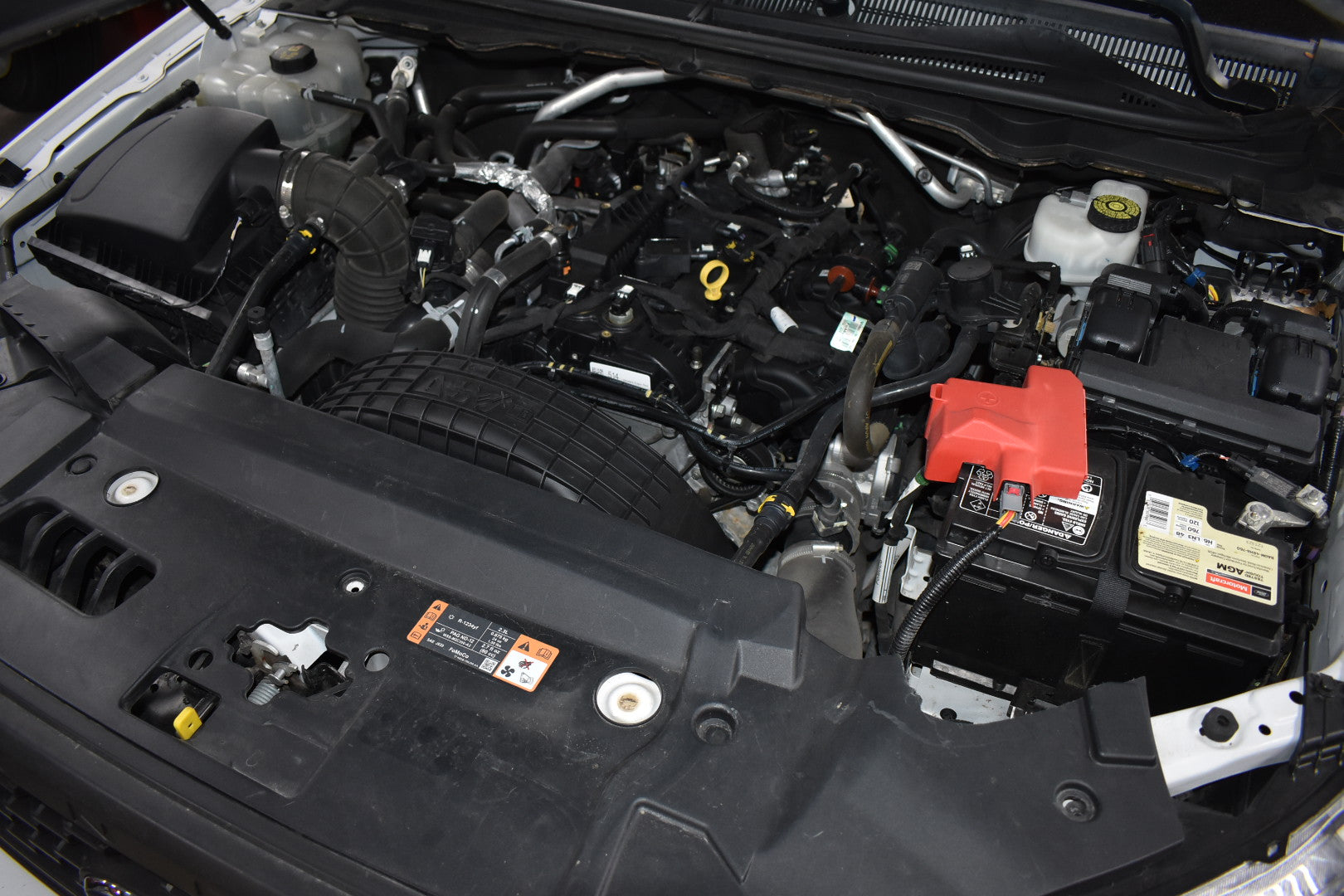 Car engine compartment with various components visible