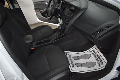 Car interior with a black and white foot mat on the floor