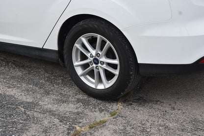 Car tire with a visible brand logo on a gray pavement