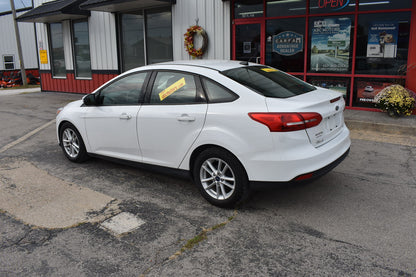 White car parked in front of a car dealership