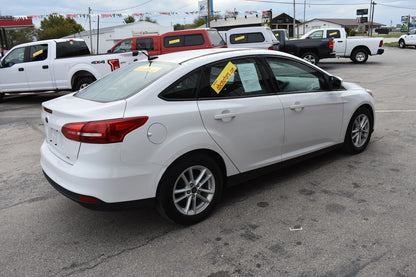 White car with sale signs in a used car lot
