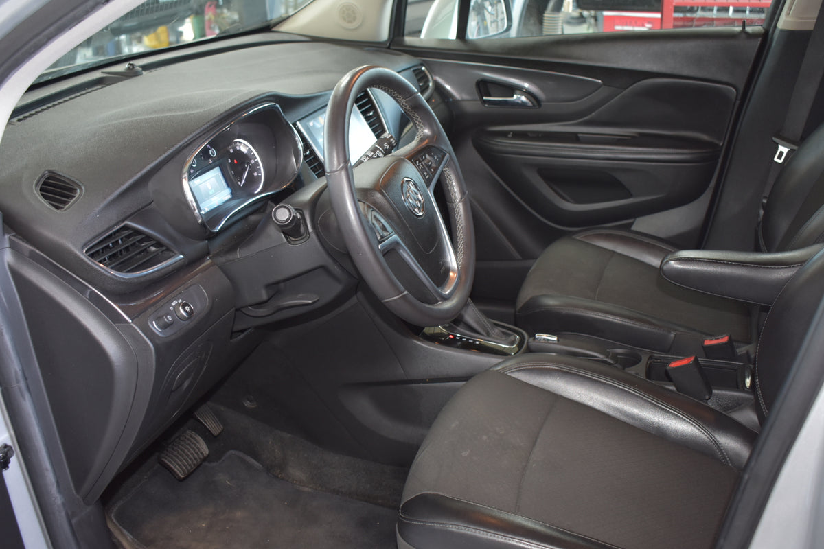 Black leather interior of a car, showing the driver's seat, steering wheel, dashboard, and center console.