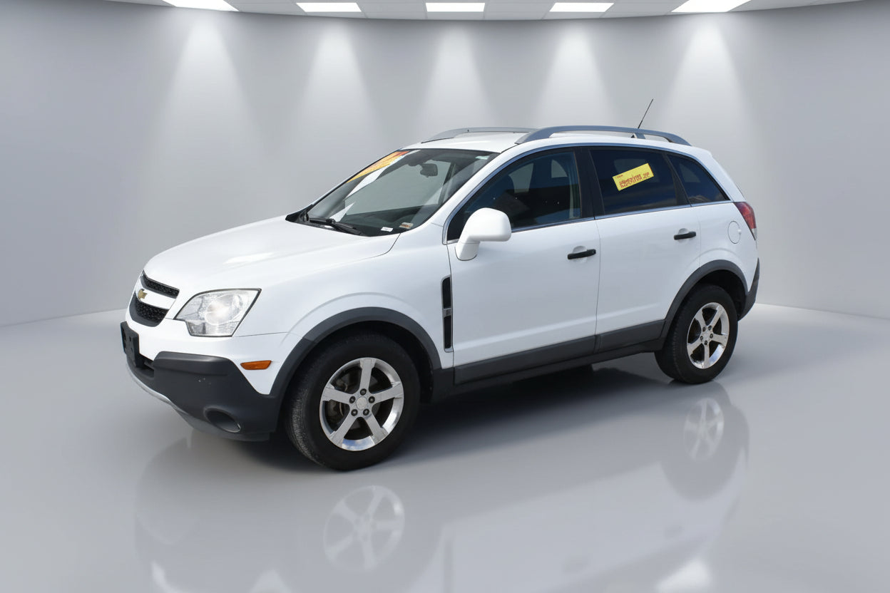 White SUV parked in front of a building with signs on the windshield.
