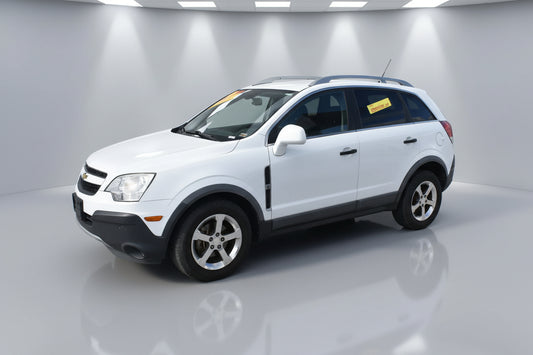 White SUV parked in front of a building with signs on the windshield.