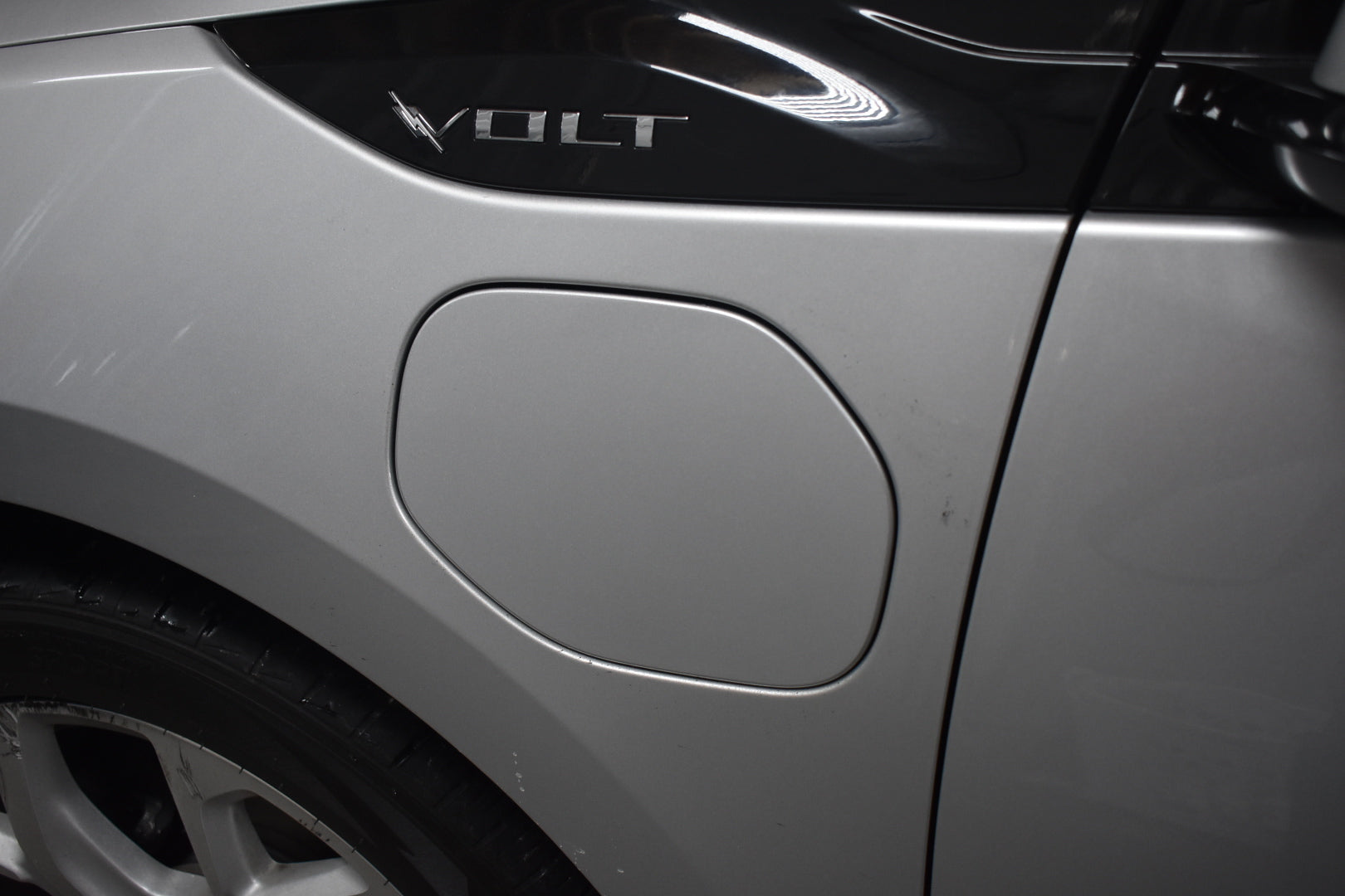 Close-up of a car door with 'VOLT' branding on a gray vehicle.