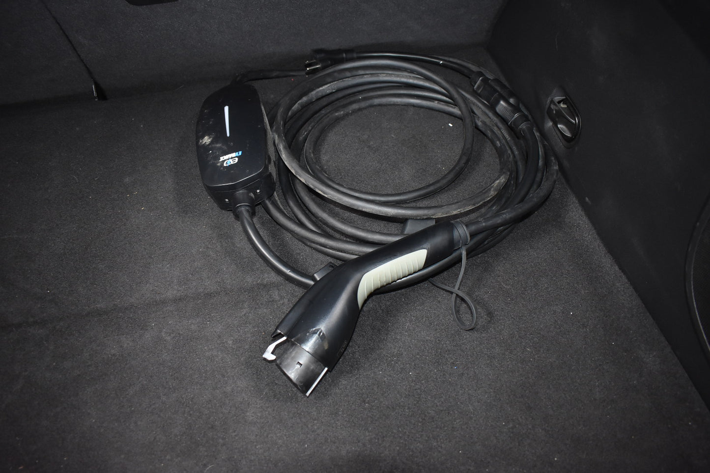 Electric vehicle charging cable in a car trunk