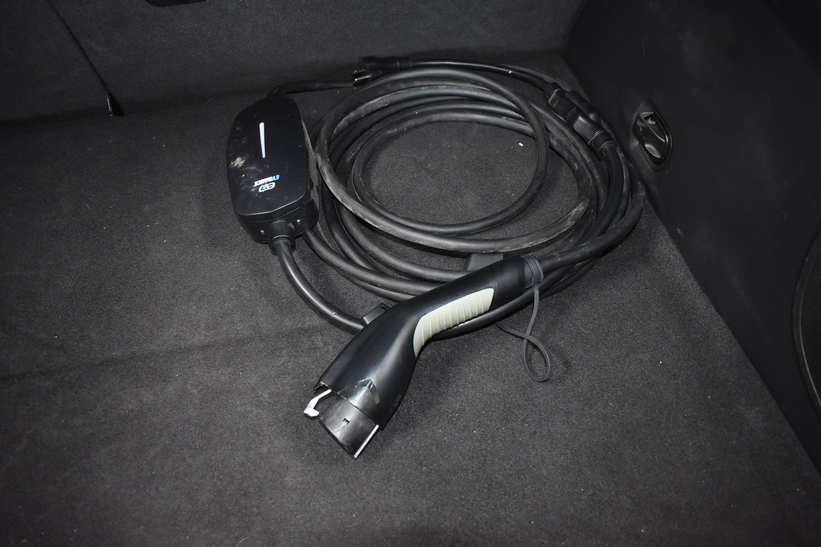Electric vehicle charging cable in a car trunk