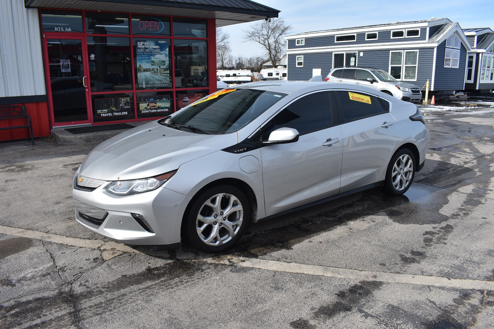 Silver car parked in front of a building with a red door