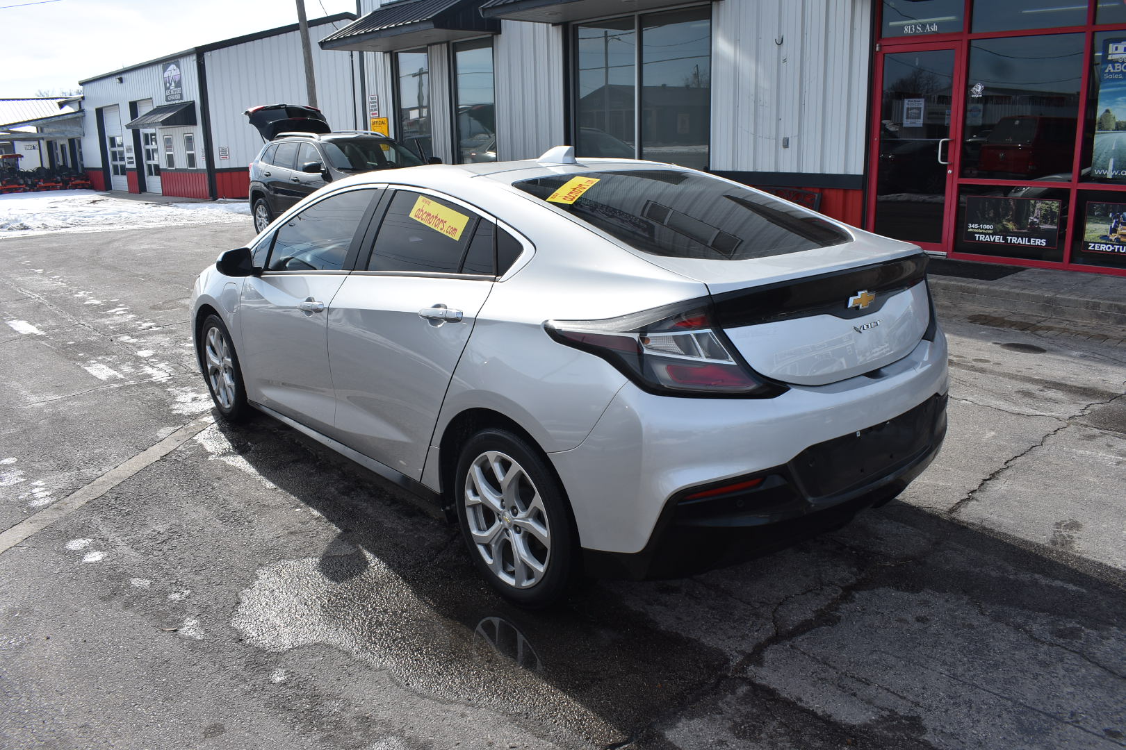 White Chevrolet car parked in a lot with a building in the background