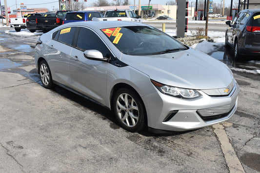 Silver Chevrolet car with sale tags in a parking lot