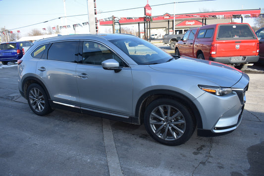 Silver SUV parked in a lot with a gas station in the background
