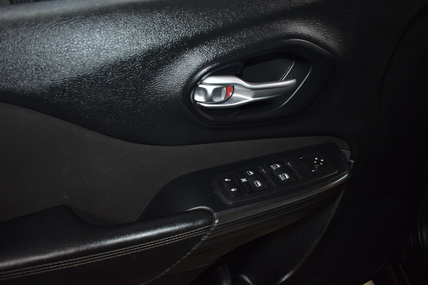 Close-up of a car door handle and panel with visible branding.