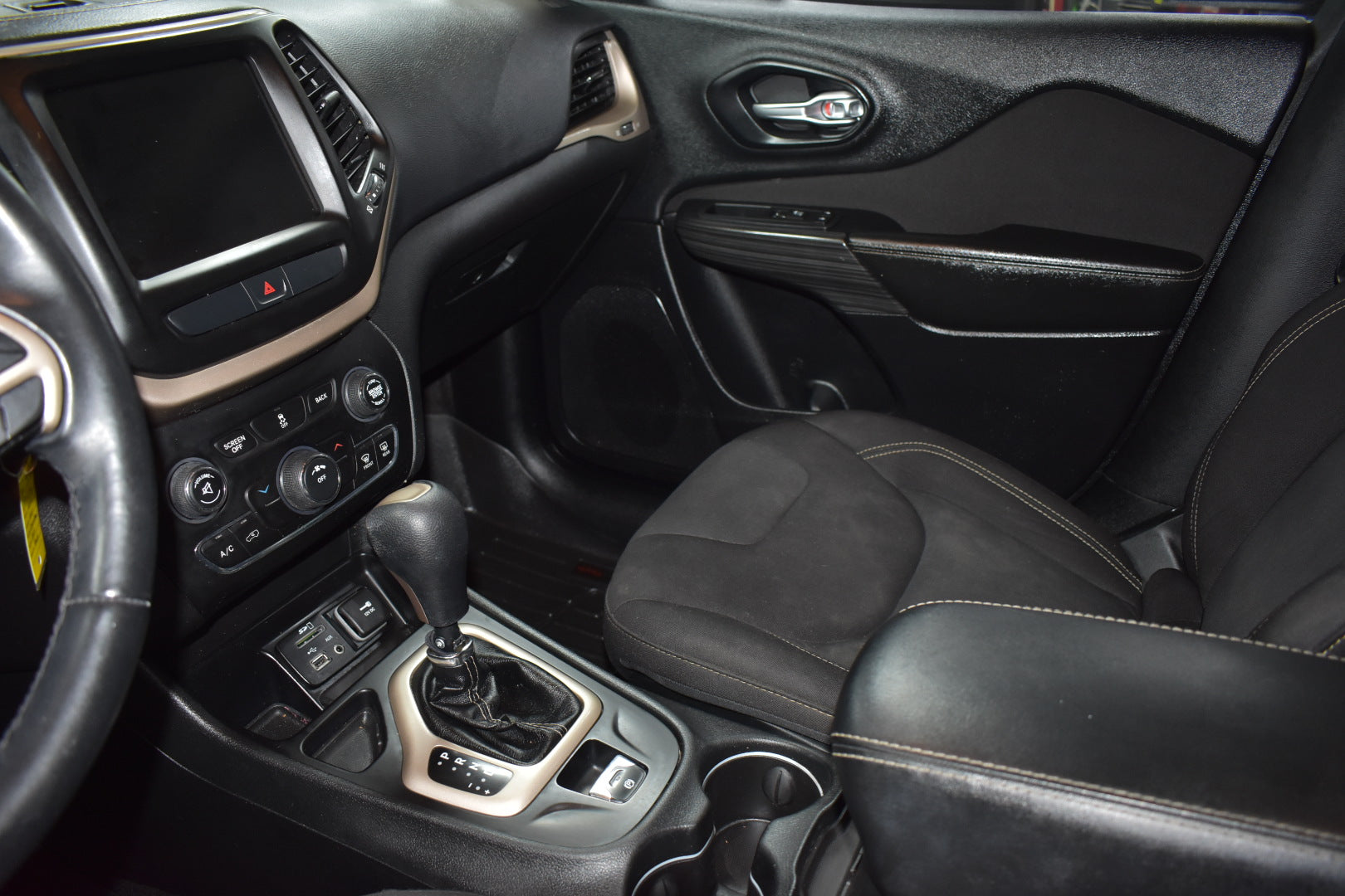 Car interior with steering wheel, dashboard, and seat.