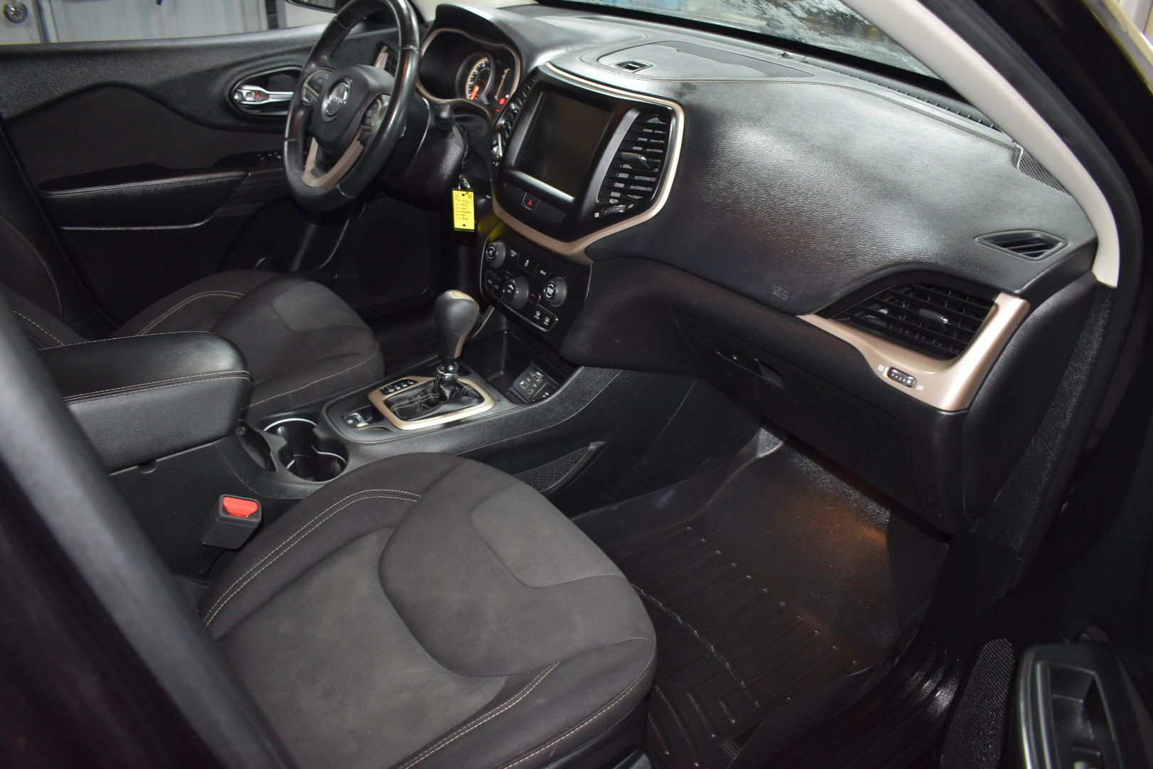 Car interior with dashboard, steering wheel, and seats.
