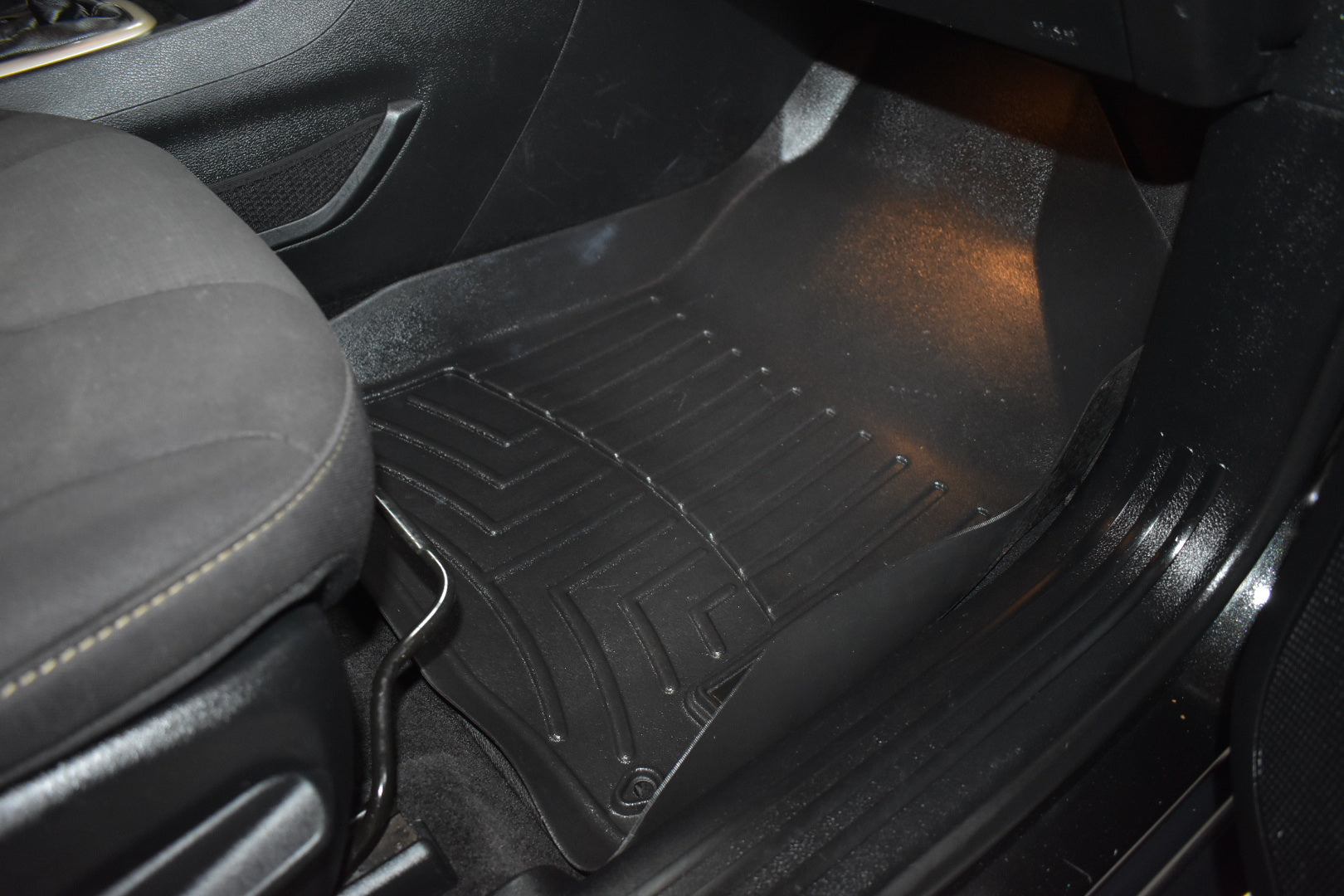 Black car floor mat in a vehicle interior