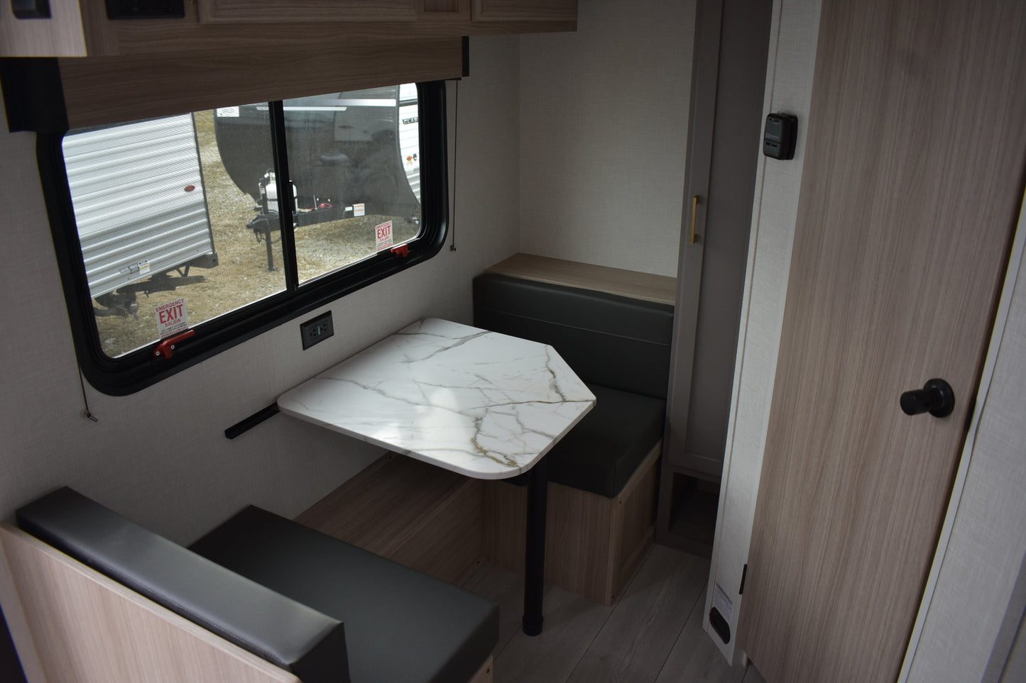 Small dining area inside a vehicle with a table and benches.