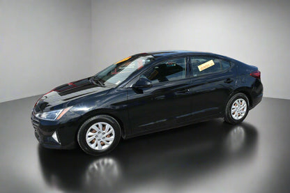 Black sedan car parked in front of a dealership building