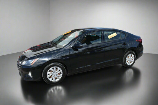 Black sedan car parked in front of a dealership building