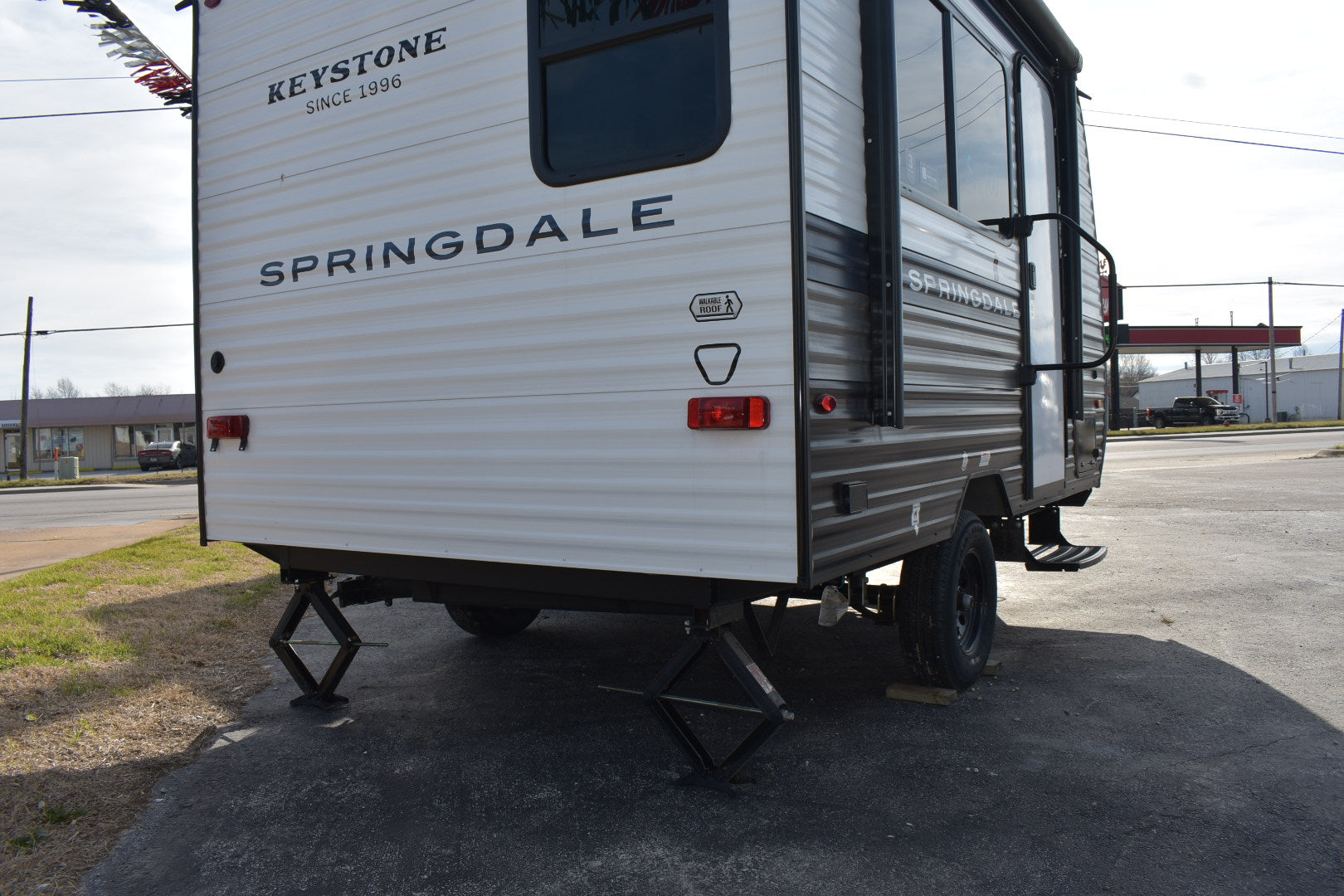 Back view of a Keystone Springdale travel trailer on a paved surface.