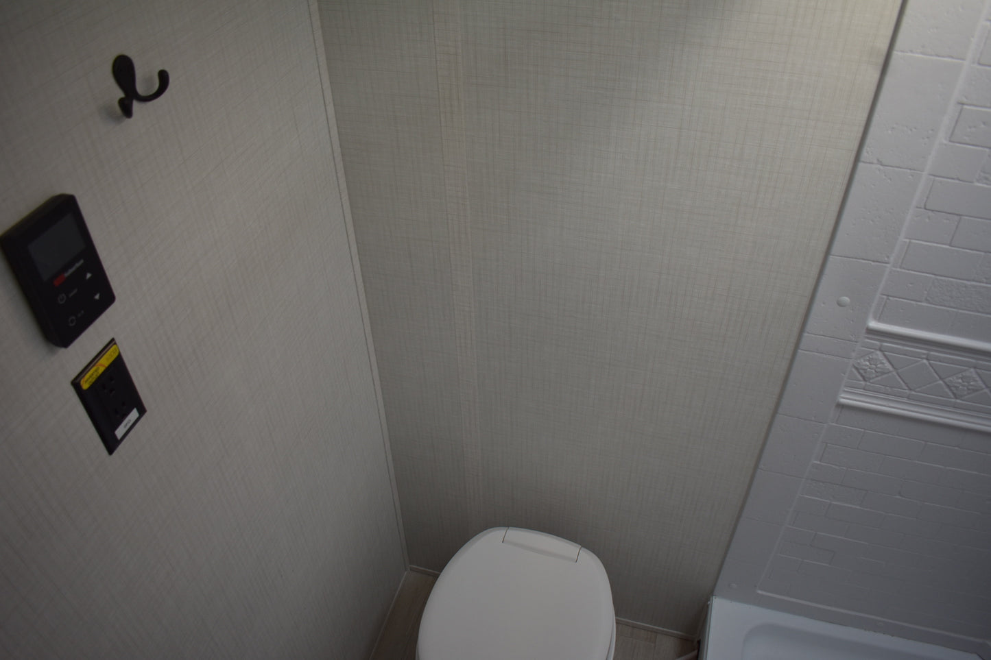 Bathroom corner with a toilet and shower stall.