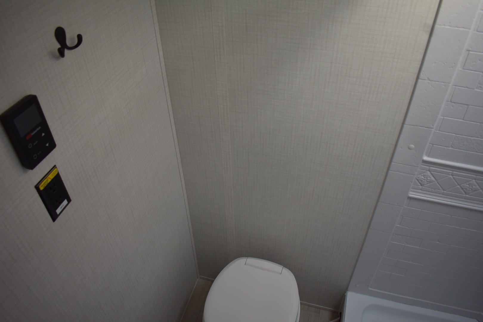Bathroom corner with a toilet and shower stall.