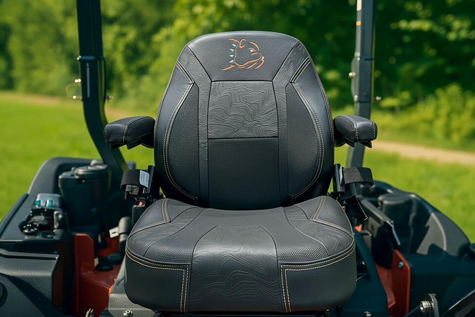 Black leather seat with a logo on a MOWER, set against a green outdoor background.