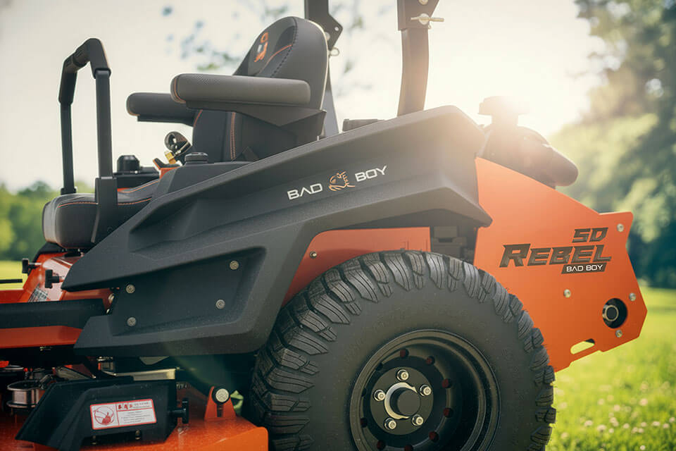 Close-up of a lawn mower with 'Bad Boy' branding on a grassy background